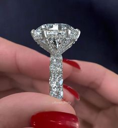 a woman's hand holding a diamond ring