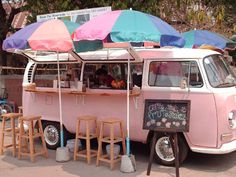 an old pink van with umbrellas on the roof