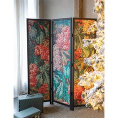 a room divider with flowers on it next to a christmas tree