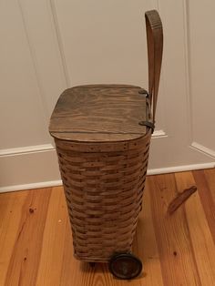 a brown wicker basket sitting on top of a wooden floor next to a door