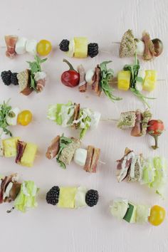 several skewers of different types of food are arranged on a white table top