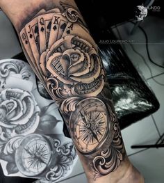 a man's arm with a clock and playing cards on it