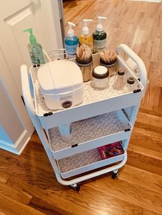 a white cart with some bottles on top of it