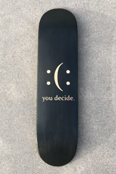 a black skateboard with the words you decide on it's bottom and an upside down crescent