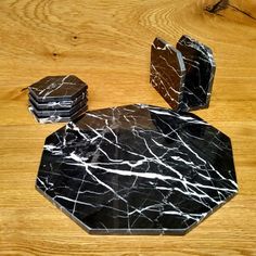 black marble coasters sitting on top of a wooden table