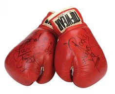 two red boxing gloves with autographs on the front and back of each glove