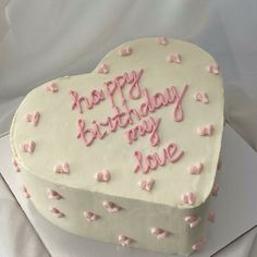 a heart shaped birthday cake with pink frosting