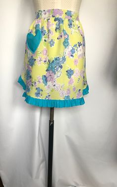 a mannequin wearing a yellow skirt with blue trims and flowers on it