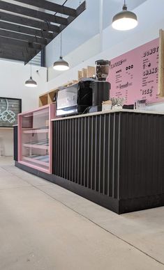 a pink and black counter sitting inside of a building next to a wall with writing on it