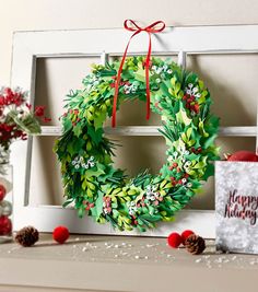 a christmas wreath is hanging on the mantle