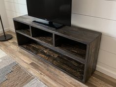 a flat screen tv sitting on top of a wooden entertainment center