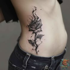 a woman's stomach with a rose tattoo on it