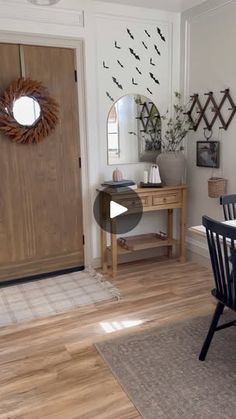 a dining room table and chairs in front of a wooden door with birds on it