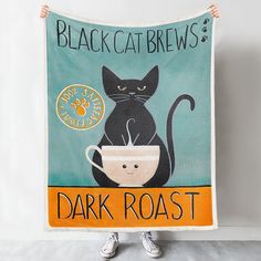 a black cat is sitting on top of a coffee cup with the words dark roast