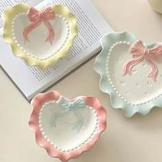 three plates with bows on them sitting next to an open book