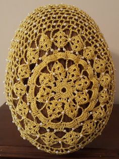 a crocheted egg sitting on top of a wooden table