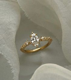 a close up view of a gold ring with an oval cut diamond in the center