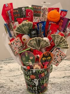 a bucket filled with candy and money sitting on top of a counter