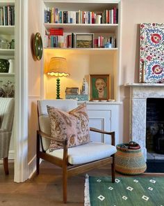 a living room filled with lots of furniture and bookshelves next to a fire place