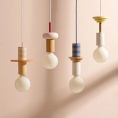 three light bulbs hanging from the ceiling in different shapes and sizes, with one bulb turned upside down