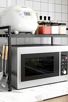 a microwave oven sitting on top of a kitchen counter next to a stove and utensils