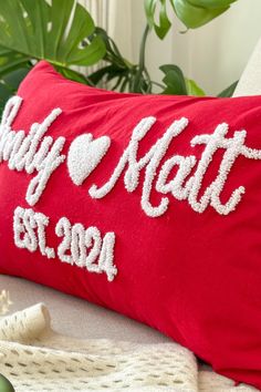 a red pillow with the words, my love mat on it and a white heart