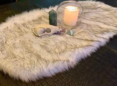 a candle and some rocks on a fur rug