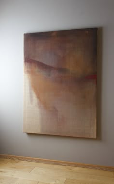 an abstract painting hangs on the wall above a wooden floor