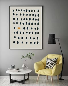 a yellow chair sitting in front of a white table with a black lamp on it