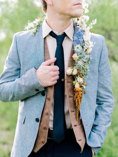 a man wearing a suit and tie with flowers on his lapel