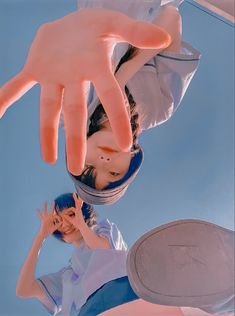 two girls are looking up at the sky with their hands on top of each other