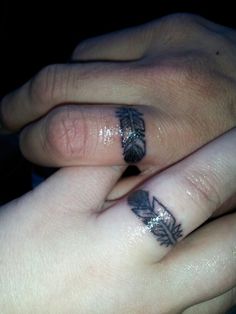 two people with tattoos on their fingers