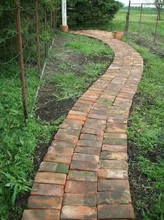 a brick path in the middle of a grassy area