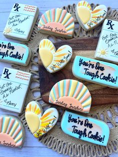 decorated cookies with words and pictures on them sitting on a doily next to a wooden board