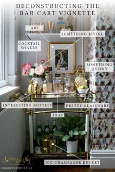 a gold bar cart with lots of bottles and flowers on it in front of a window