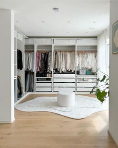 a walk in closet with lots of clothes on hangers and carpeted flooring