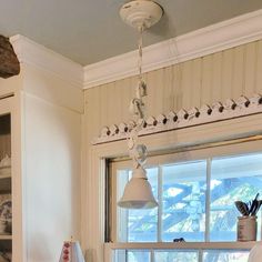 a kitchen with white cabinets and an island in front of a window that looks out onto the ocean