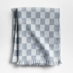 a gray and white checkered blanket with fringes