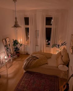 a bed room with a neatly made bed next to a window and a rug on the floor