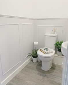 a white toilet sitting next to a sink in a bathroom