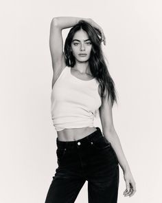 a woman in black jeans and a white tank top