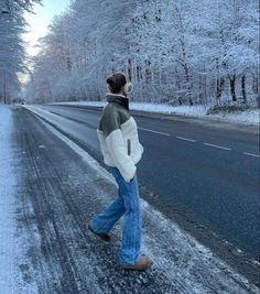 a person walking down the road in the snow