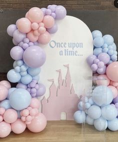 there is a castle made out of balloons on the table with a sign that says once upon a time