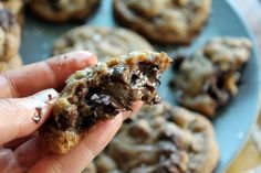 a hand holding a half eaten chocolate chip cookie