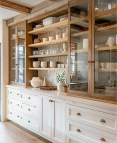 a kitchen with white cabinets and wooden shelves