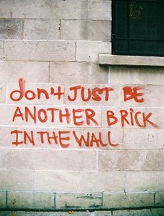 graffiti on the side of a brick building reads, don't just be another brick in the wall