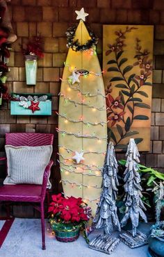 a surfboard is decorated with christmas lights and other holiday decorations in front of a brick wall