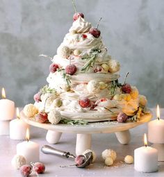 a white cake sitting on top of a table next to candles