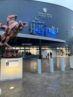 the entrance to harry potter's studio at universal studios, with statues of hogwarts and horses