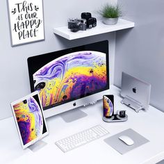 an apple desktop computer sitting on top of a white desk next to a monitor and keyboard